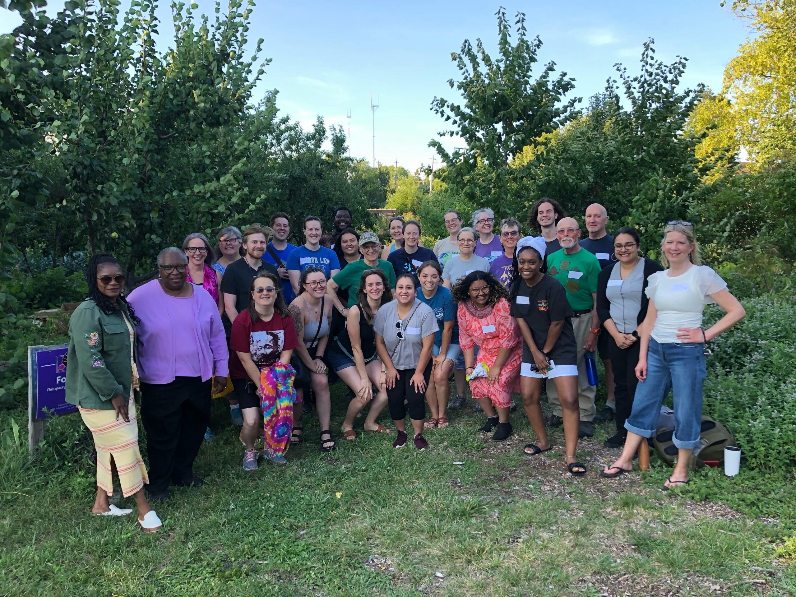 Members of the Fair Future Movement standing together in a group at Victory Garden Initiative's urban farm looking happy and energized