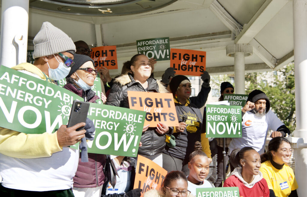 Milwaukee community members protesting in front of We Energies about their continued rate increases. Folks are holding signs that read "Fight for our Lights" and "Affordable Energy Now!"