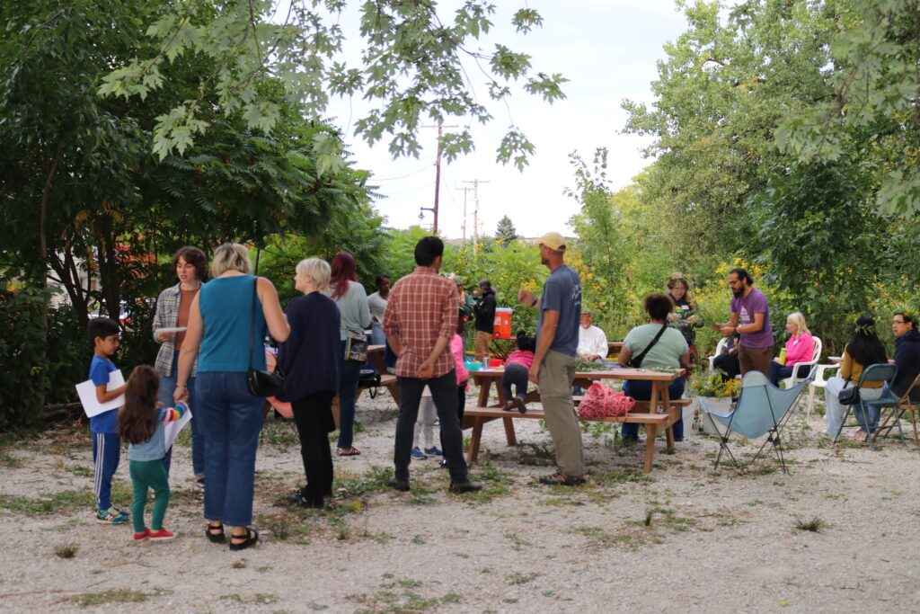 Members of the Fair Future Movement gathered at Turtle Park, talking, sharing food, and making flower crowns